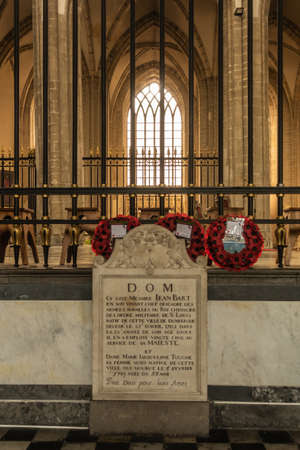Dunkerque, France - September 16, 2018: Inside Saint Eloi Church in Dunkirk. Tombstone of Jean Bart and his wife. Red poppy wreaths, brown stone church wall with window as background.のeditorial素材