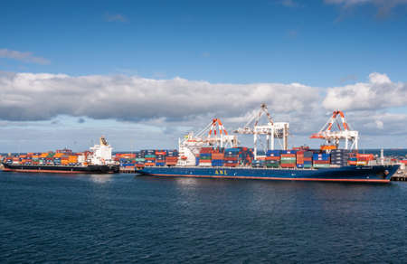 Fremantle, Australia - November 25. 2009: Two container ships unload at the sea harbor under blue...
