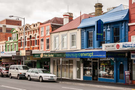 Hobart, Tasmania, Australia - December 14, 2009:  Criterion shopping street with smaller merchant stores in older houses. Blue painted Enwrapt gift store up front. Street with cars and people.のeditorial素材