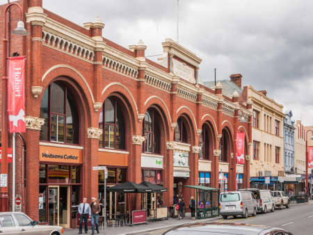 Hobart, Tasmania, Australia - December 14, 2009:  Red Historic Alexander George Webster building with windows in arches houses different shops. Street scene with people and cars.のeditorial素材