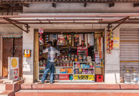 Belur, Karnataka, India - November 2, 2013: Closeup of small candy store selling food and drink such as Coca-Cola and single-serve packagings of different household stuff.のeditorial素材