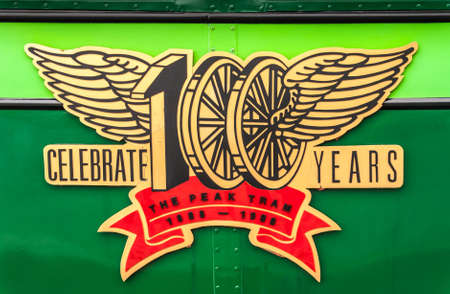 Hong Kong, China  - May 12, 2010: Closeup of golden emblem, winged wheels, of the Peak Tram as seen on the side of cariage. Red centennial text.のeditorial素材