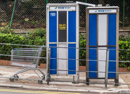 Hong Kong Island, China  - May 12, 2010: Closeup of Blue Public Wifi hot spot near Stanley market has a shopping cart nearby. Green foliage in back.のeditorial素材