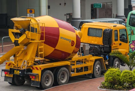 Hong Kong Island, China  - May 14, 2010: Closeup of yellow and red concrete mixer truck parked in street.のeditorial素材