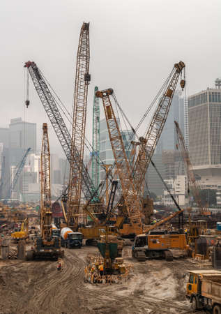 Hong Kong Island, China  - May 14, 2010: Plenty of yellow cranes on new construction site adjacent to Two International Finance Centers. Highrises in back against foggy silver sky.のeditorial素材