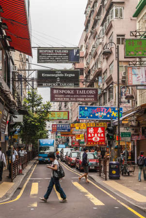 Hong Kong, China  - May 13, 2010: Kowloon mainland Section. Colorful commercial sign, print and lights, English, Mandarin and Kantonese, in shopping street. Taxi stand, people and truck.のeditorial素材