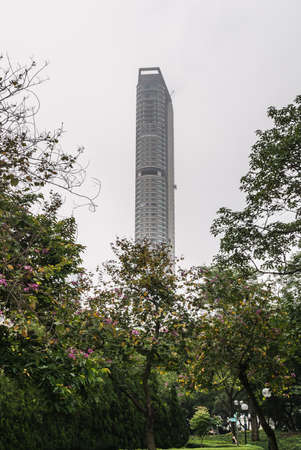 Hong Kong, China  - May 13, 2010: Kowloon Park, Tsim Sha Tsui. Hyatt Regency highrise hotel towers over flowering trees in the park.のeditorial素材
