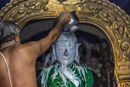 Belur, Karnataka, India - November 2, 2013: Chennakeshava Temple. Half naked priest pours coagulated...