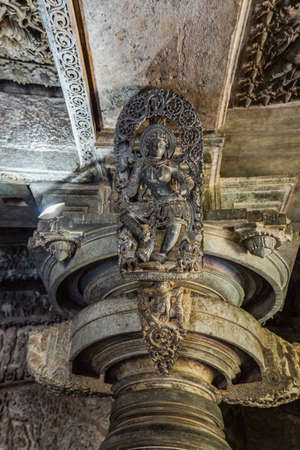 Halebidu, Karnataka, India - November 2, 2013: Hoysaleswara Temple of Shiva. Closeup of Madanakai or Salabhanjika, a dancing girl statue against ceiling on top of pillar. Gray brownish stone.のeditorial素材