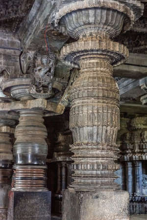 Halebidu, Karnataka, India - November 2, 2013: Hoysaleswara Temple of Shiva. Exquisitely decorated pillar and Madanakai or Salabhanjika, a dancing girl statue against ceiling on top of pillar. Gray brownish stone.のeditorial素材