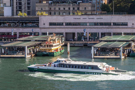 Sydney, Australia - February 12, 2019: Closeup of Ferry terminal and Circular Quay Railway Station. Ferries in action. Evening shot with sun falling on boats.のeditorial素材