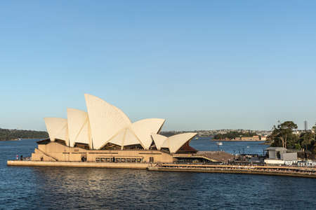 Sydney, Australia - February 12, 2019: Side view of the Opera House during sunset. Blue sky and water. Horizon is north shore of bay.のeditorial素材