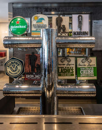 Hamilton Island, Australia - February 16, 2019: Closeup of Beer tap system at Mariners on the Marina serving Heineken, Summer Bright Lager, Iron Jack, Kirin, Furphy and James Squire ales.のeditorial素材