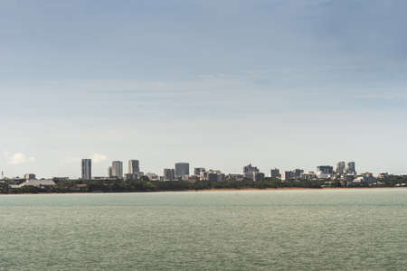 Darwin Australia - February 22, 2019: Darwin skyline seen from East Point over Fannie Bay sea water under light cloudy sky.の写真素材