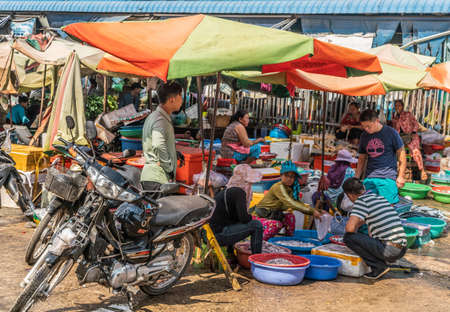 Sihanoukville, Cambodia - March 15, 2019: Phsar Leu Market. Wider shot of scene with several fish vendors doing business out of basin filled with seafood.のeditorial素材