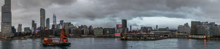 Hong Kong, China - March 7, 2019: Very early morning under dark rainy sky. Panorama shot of Kowloon skyline with Hong Kong Coliseum at center with plenty highrise buildings.のeditorial素材