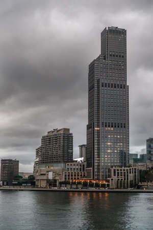 Hong Kong, China - March 7, 2019: Very early morning under dark rainy sky. Tower building at intersection of Salisbury and Chatham roads and Ave of the Stars along Victoria harbor.のeditorial素材