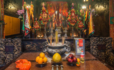 Hong Kong, China - March 8, 2019: Man Mo Yi Tai Taoist Temple in Fu Shin Street. Main altar with incense stand and gift table up front and plenty of colorful decorations.のeditorial素材
