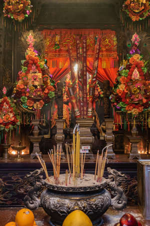 Hong Kong, China - March 8, 2019: Man Mo Yi Tai Taoist Temple in Fu Shin Street. Portrait of Main altar with incense stand and gift table up front and plenty of colorful decorations.のeditorial素材