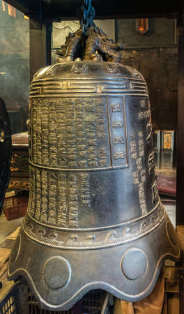 Hong Kong, China - March 8, 2019: Man Mo Yi Tai Taoist Temple in Fu Shin Street. Closeup of Big metal bell with inscriptions.のeditorial素材