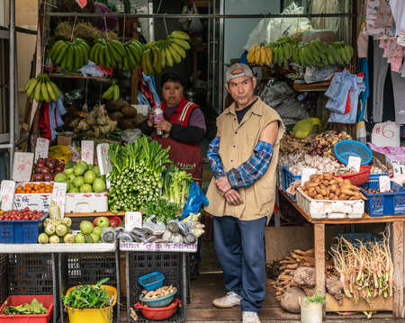 Hong Kong, China - March 8, 2019: Tai Po Market in New Territory. Couple merchants guard the rich display of vegetables in all colors in front of their small shop.のeditorial素材