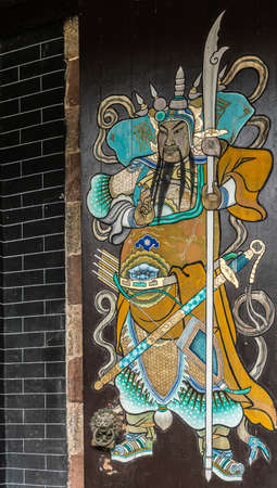 Hong Kong, China - March 8, 2019: New Territory. Tang Family Ancestral Home, turned into museum and cultural center. Colorful painting of historic fierce looking armed guardian on entrance door.のeditorial素材