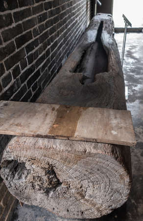 Hong Kong, China - March 8, 2019: Tai Fu Tai Ancestral home in New Territory. Closeup of antique wooden peanut press made of tree trunk to collect oil.のeditorial素材
