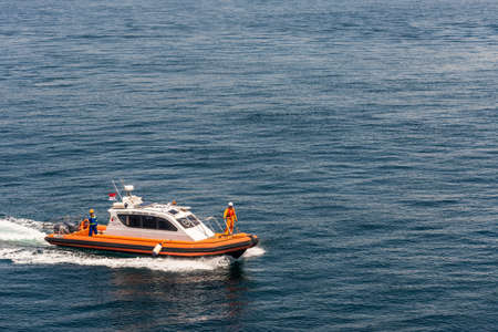 Bali, Indonesia - February 25, 2019: Outside Benoa Port. Closeup of orange pilot boat drawing a...
