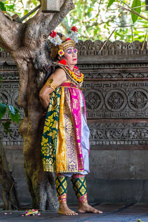 Banjar Gelulung, Bali, Indonesia - February 26, 2019: Mas Village. Play on stage setting. Closeup of captured Queen bound to tree in decorated garb of reds, golds, yellow, and green.のeditorial素材