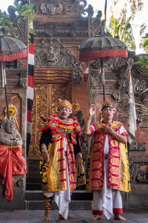 Banjar Gelulung, Bali, Indonesia - February 26, 2019: Mas Village. Play on stage setting. Two Mandarins in elaborated decorated red and yellow garments recite their lines in front of temple entrance.のeditorial素材