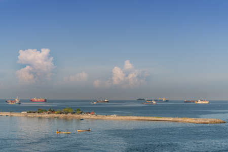 Makassar, Sulawesi, Indonesia - February 28, 2019: Early morning sky over Gusing Laelae Caddi long Island in front of the harbor under morning sky. Many ships on horizon.のeditorial素材