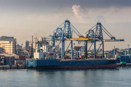 Makassar, Sulawesi, Indonesia - February 28, 2019: Early morning sky over closeup of container harbor with CTP Fortune container ship unloading, and many cranes .のeditorial素材