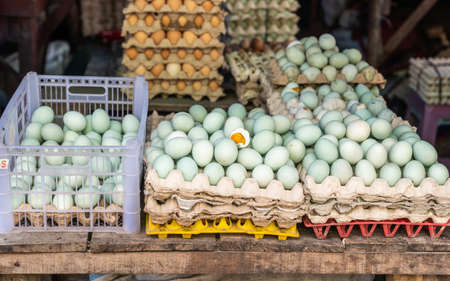 Makassar, Sulawesi, Indonesia - February 28, 2019: Terong Street Market. Closeup of stack of white cartons filled with green eggs, which seems to be boiled.の写真素材
