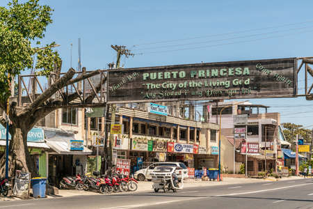 Puerto Princesa, Palawan, Philippines - March 3, 2019: Street view of Rizal Avenue with closeup of wooden banner spanning the street claiming the city is the city of the living god.のeditorial素材