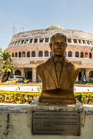 Puerto Princesa, Palawan, Philippines - March 3, 2019: Don Pedro M. Vicente statue in front of Beige stone building of Palawan Provincial Capitol under blue sky resembling beehive.のeditorial素材