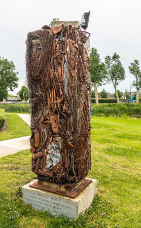 Diksmuide, Flanders, Belgium -  June 19, 2019: Old war-iron monument at IJzertoren, tallest peace monument of WW 1. Some green foliage and lawn.のeditorial素材