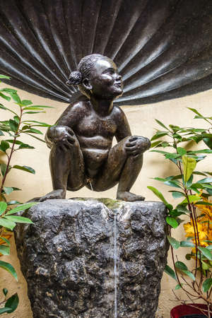 Brussels, Belgium - June 22, 2019: Closeup of iconic and original Jeanneke Pis statue, urinating on black rock.のeditorial素材