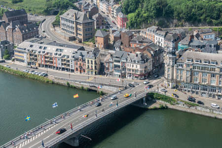 Dinant, Belgium - June 26, 2019: Seen from Citadelle. Charles de Gaulle bridge and intersection with Avenue des Combattants. River Meuse, buildings and cars with green foliage in back.のeditorial素材