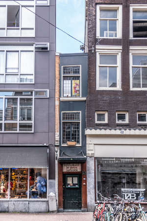 Amsterdam, the Netherlands - June 30, 2019: Smallest house and De Groene Lanteerne restaurant in Haarlemmerstraat squeezed between two other retail business buildings.のeditorial素材