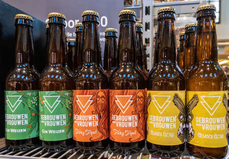 Amsterdam, the Netherlands - July 1, 2019: Closeup of three brands of Gebrouwen-Door-Vrouwen, Brewed-by-Women, beer bottles on shelf. Green, red and gold labels.のeditorial素材