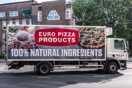 Amsterdam, the Netherlands - July 1, 2019: Euro Pizza producer and merchant deliver truck. Side plastered by huge photos of Pizza and ingredients. Street scene with green foliage.のeditorial素材