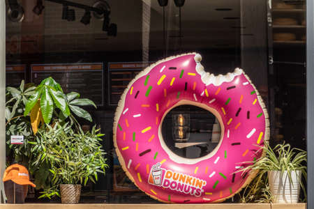 Amsterdam, the Netherlands - July 1, 2019: Giant blown-up image of pink DunkinâDonuts image in window of shop with same name.のeditorial素材
