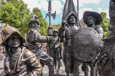 Amsterdam, the Netherlands - July 1, 2019: De Nachtwacht compostion of statues on Rembrandtplein. Closeup of body of fivesoldier figures against green foliage.のeditorial素材
