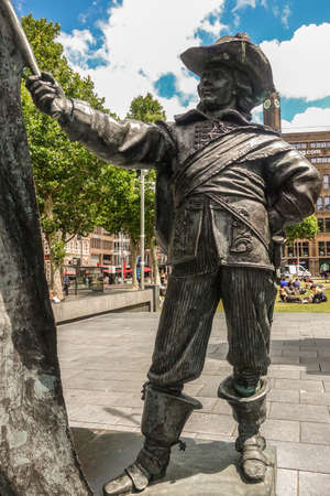 Amsterdam, the Netherlands - July 1, 2019: De Nachtwacht compostion of statues on Rembrandtplein. Closeup of The Ensign or standard-bearer against green foliage and buidlings. people around.のeditorial素材