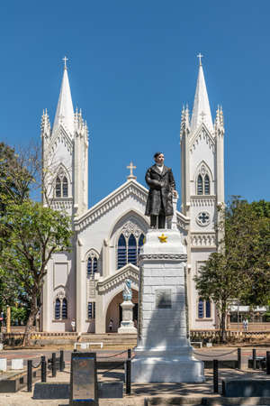 Puerto Princesa, Palawan, Philippines - March 3, 2019: Jose P. Rizal statue in front of White Immaculate Conception Cathedral entrance with twin towers against blue sky.のeditorial素材