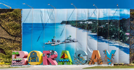 Manoc-Manoc, Boracay, Philippines - March 4, 2019: Colorful giant tourist welcome sign spelling out the name set against photo banner of sandy beach.のeditorial素材