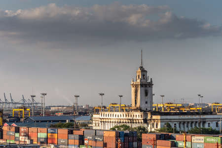 Manila, Philippines - March 5, 2019: South Harbor evening twilight. Bureau of Customs and Finance office building with tower behind stacks of shipping containers and under light blue sky.のeditorial素材