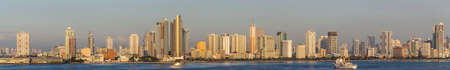 Manila, Philippines - March 5, 2019: South Harbor evening twilight shines on panorama of tall buildings along the shoreline south of Ocean Park. Amosup rescue ship on dark blue sea water.のeditorial素材