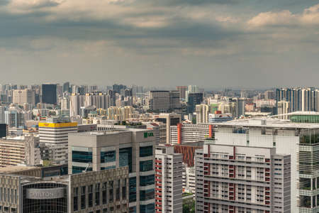 Singapore - March 20, 2019: Shot over hundreds of skyscrapers under heavy cloudy sky. Carlton hotel in front and more in photo.のeditorial素材