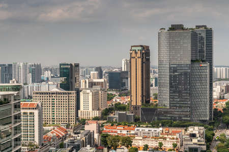 Singapore - March 20, 2019: Shot over hundreds of skyscrapers under heavy cloudy sky. Centered on Raffles Hospital and Andaz tower by Hyatt. Smaller buildings with red roofs in front.のeditorial素材